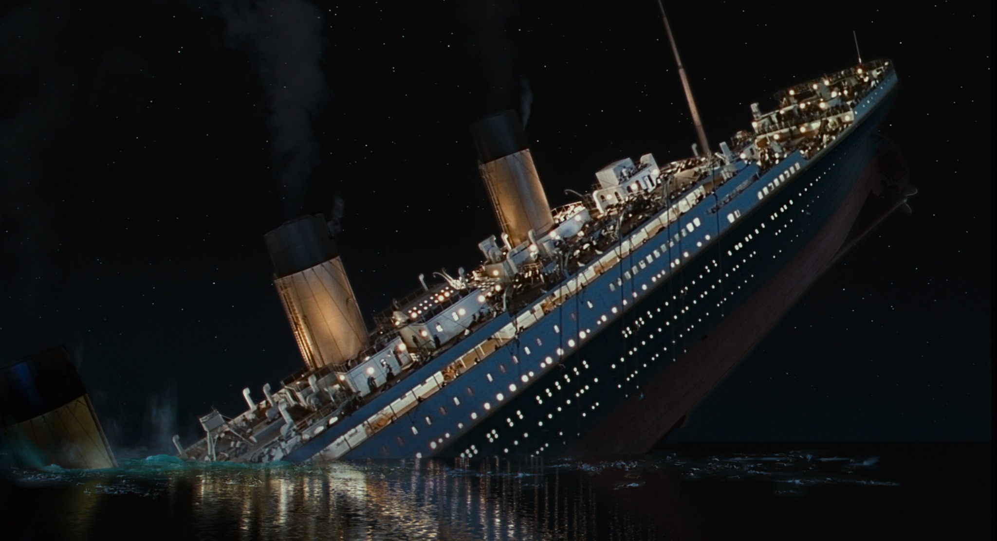 A dramatic scene showing the RMS Titanic breaking apart and sinking into the Atlantic Ocean, depicting the real-life 1912 maritime disaster