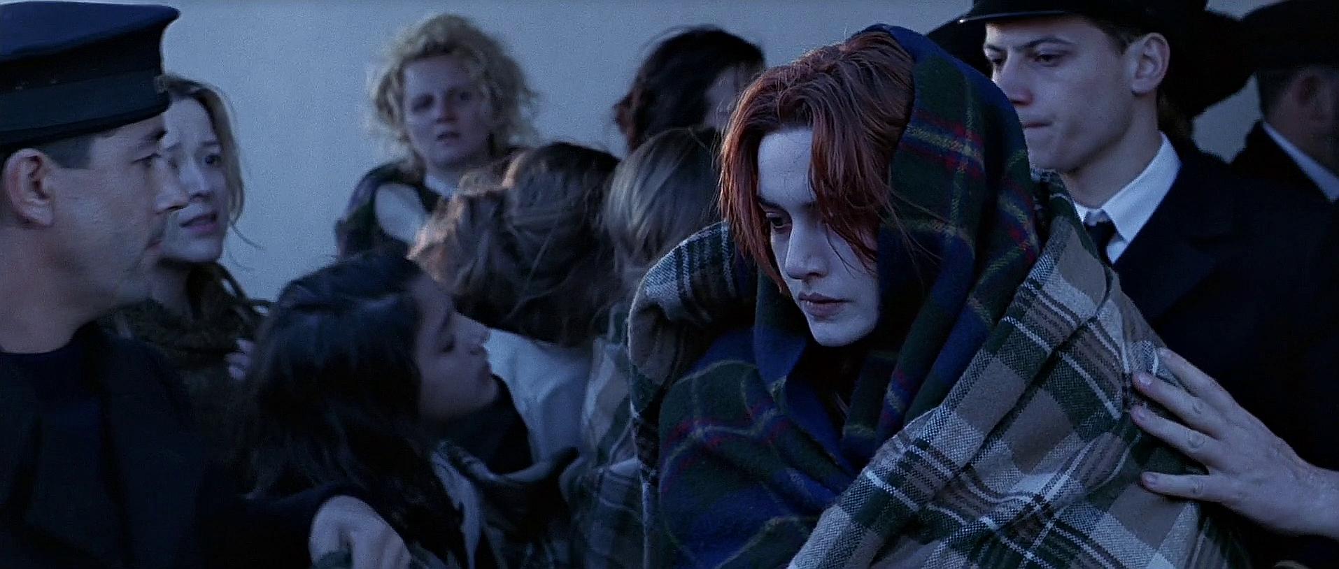 Kate Winslet as Rose DeWitt Bukater wrapped in a blanket among Titanic survivors after being rescued by the RMS Carpathia, highlighting the aftermath of the tragedy.