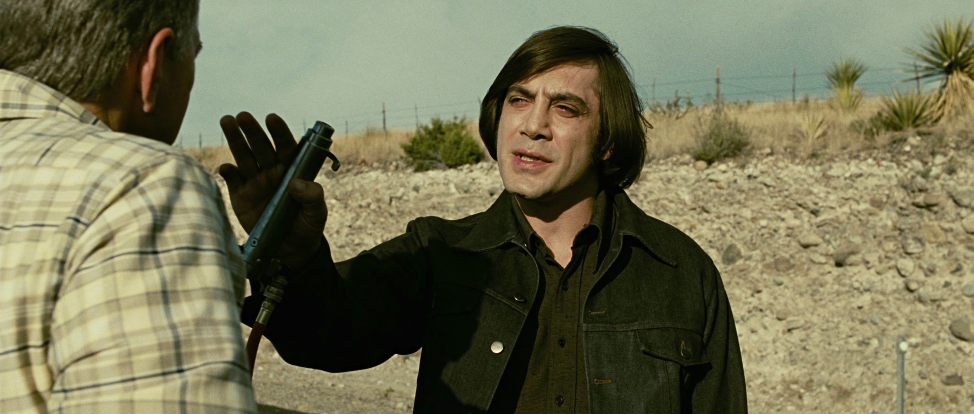 Anton Chigurh, played by Javier Bardem, using a captive bolt pistol to kill a man in a roadside encounter