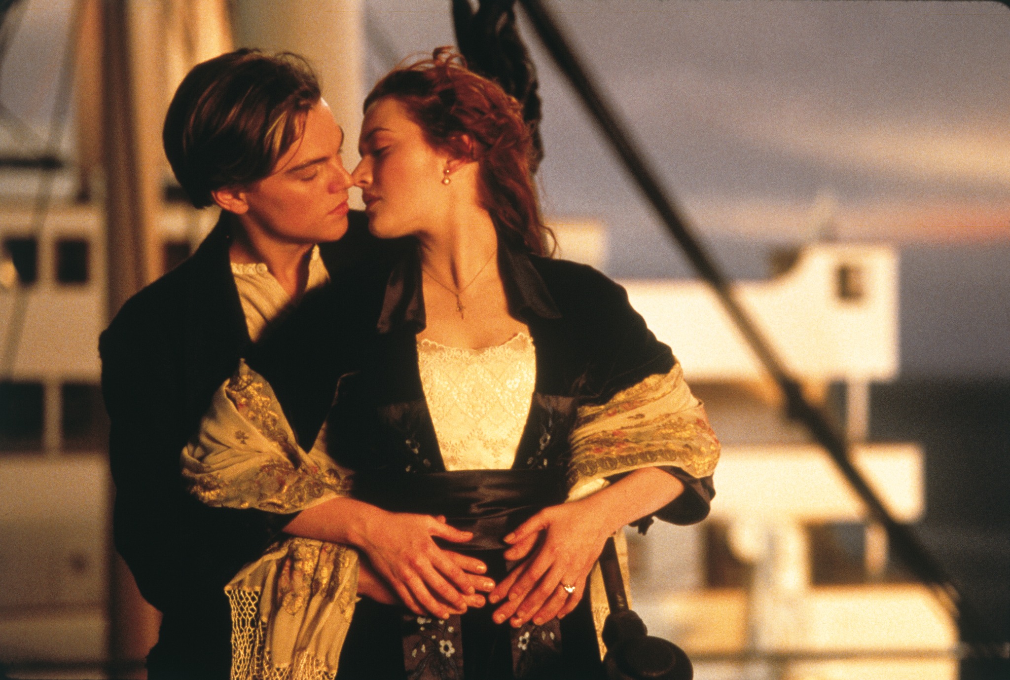 Leonardo DiCaprio and Kate Winslet as Jack and Rose share a romantic moment on the deck of the Titanic at sunset.